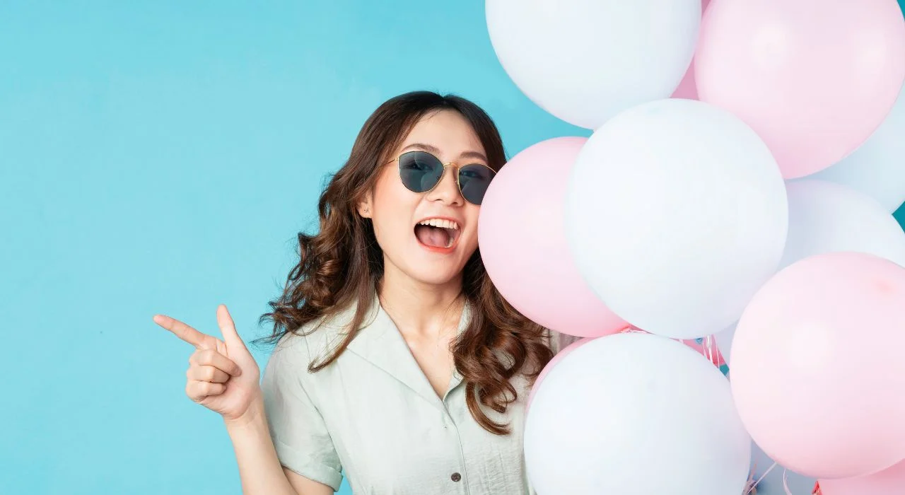 Ung kvinde med helium balloner